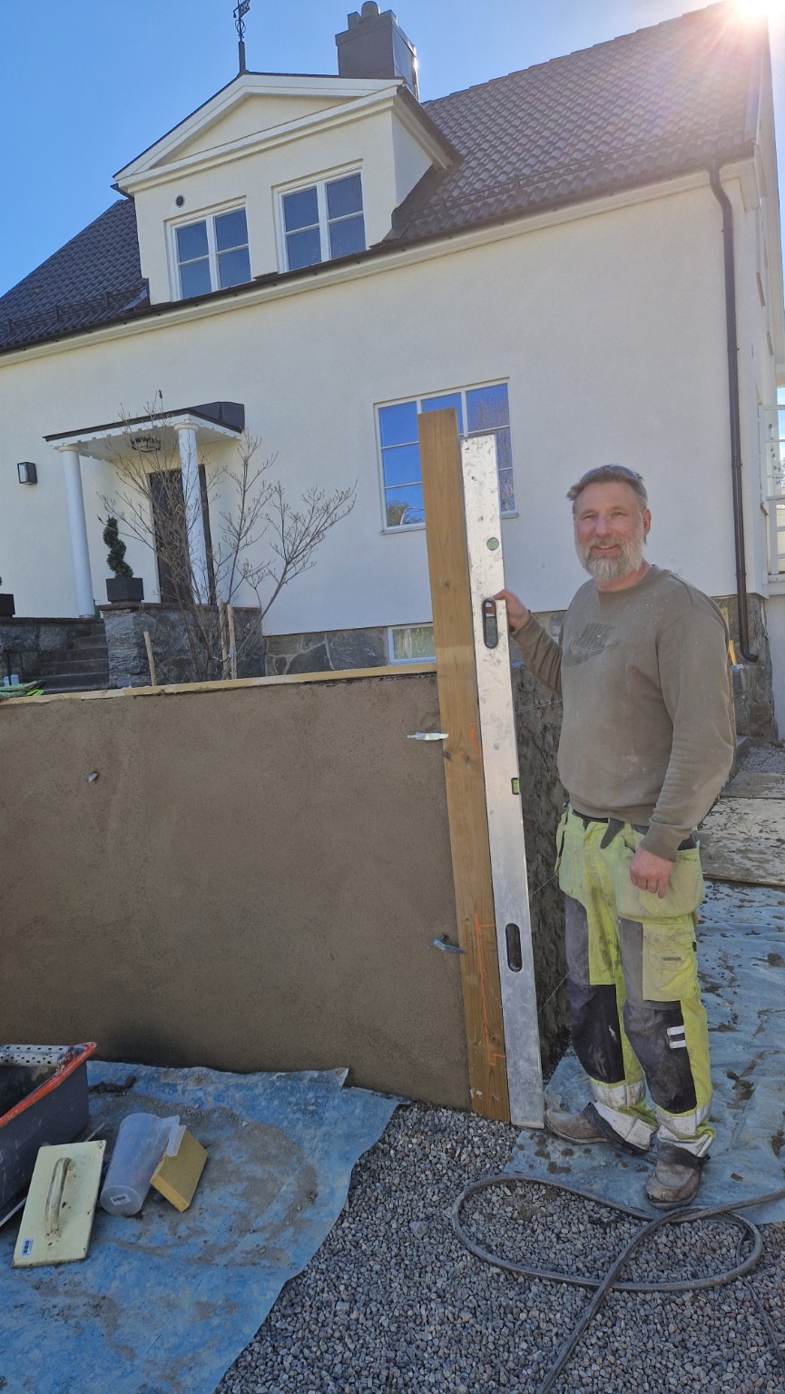 Hantverkare kontrollerar mur med vattenpass